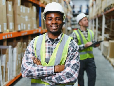 Two warehouse workers checking and controlling boxes in warehouse