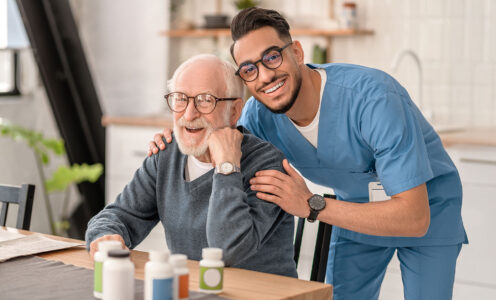 Smiling cheerful young medical worker dressed in uniform embracing a patient