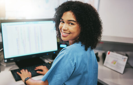 Nurse and receptionist at hospital on a computer working at her desk